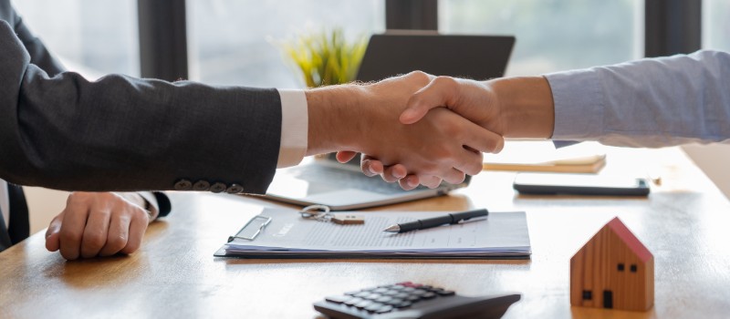 Lease, rental and selling home. Dealership manager smile handshake to the new homeowner.